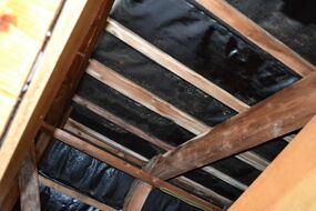 Holzkonstruktion eines Dachstuhls mit Wasserschaden und Schimmelpilzbefall.